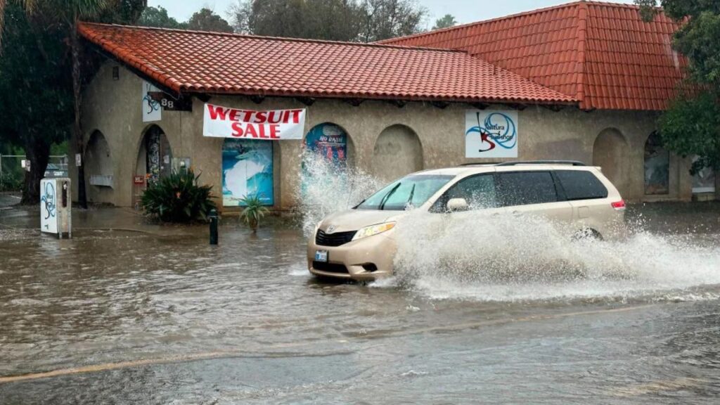 In Ventura, California, a car travels through water on a flooded street.