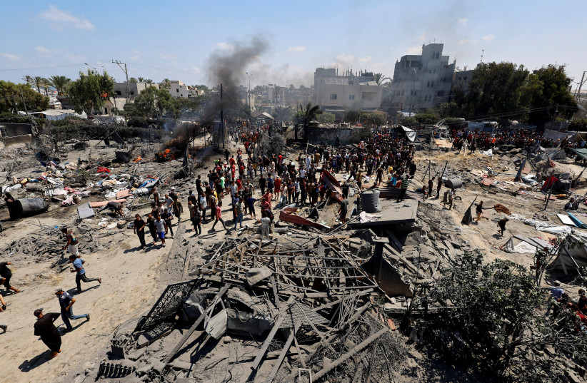 Palestinians gather near damages, following what Palestinians say was an Israeli strike at a tent camp in Al-Mawasi area, amid Israel-Hamas conflict, in Khan Younis in the southern Gaza Strip July 13, 2024.