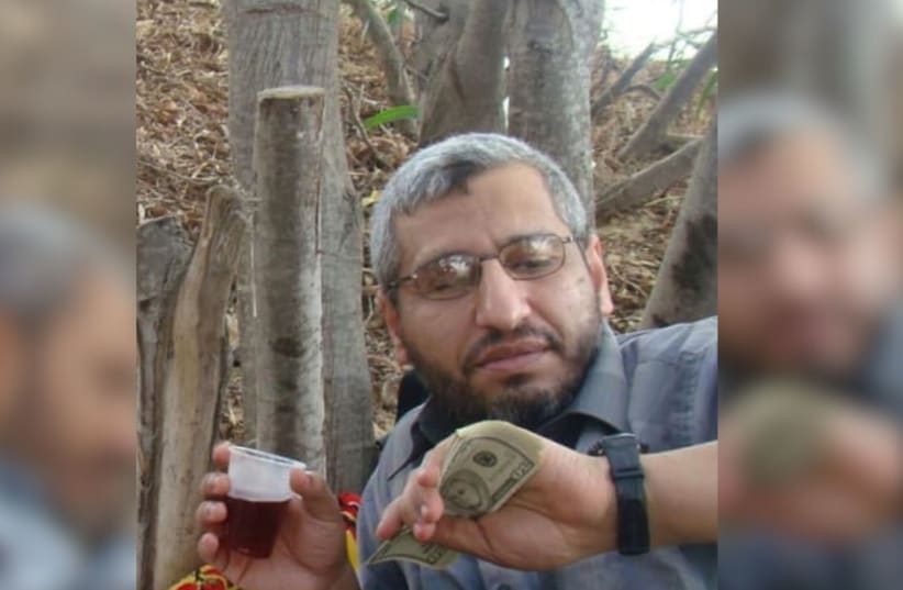 The newest photo of Muhammed Deif (right) holding US dollars and a plastic cup of juice.