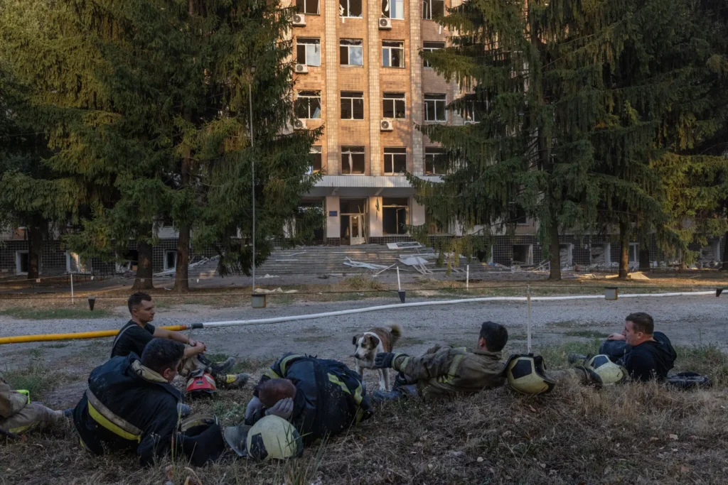 Firefighters resting on Tuesday with their rescue dog after trying to find people in the rubble at the Ukrainian military’s Institute of Communications in the city of Poltava.